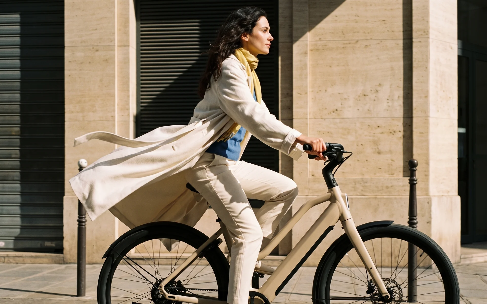A rider in everyday clothes on an ARLO L1 in Dune, upright on a sunlit city street