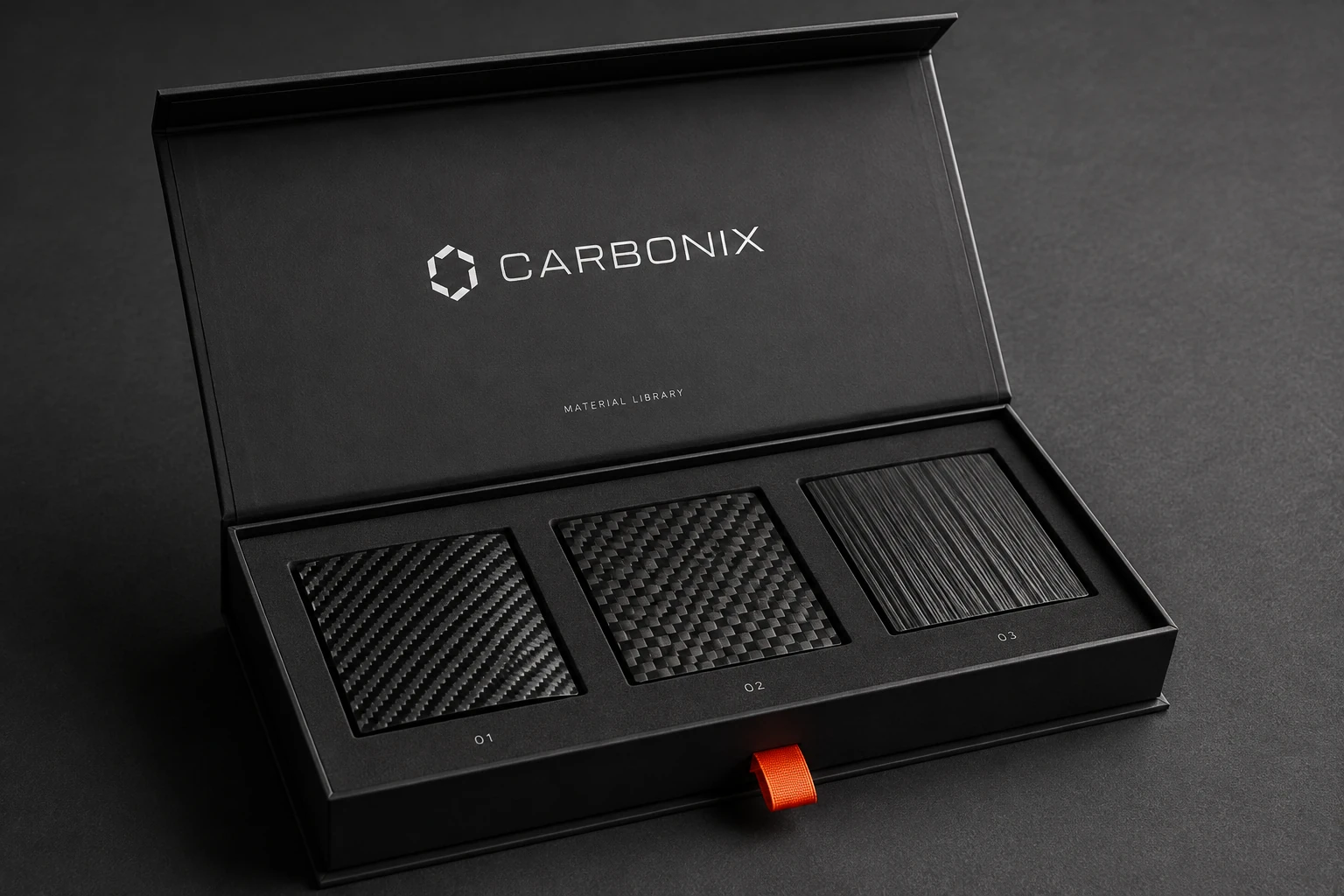 Black Carbonix material sample box with three carbon fiber swatches and a small orange pull tab.